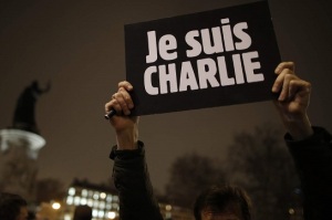 Un uomo tiene in mano un cartello con scritto "Io sono Charlie" in Piazza della Repubblica a Parigi (foto: REUTERS/Christian Hartmann)